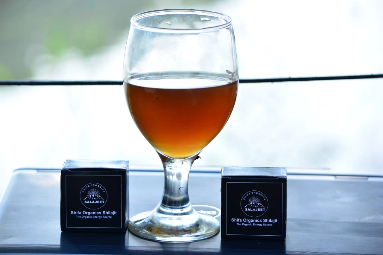 Glass of Shilajit drink with Shifa Organics packaging on display